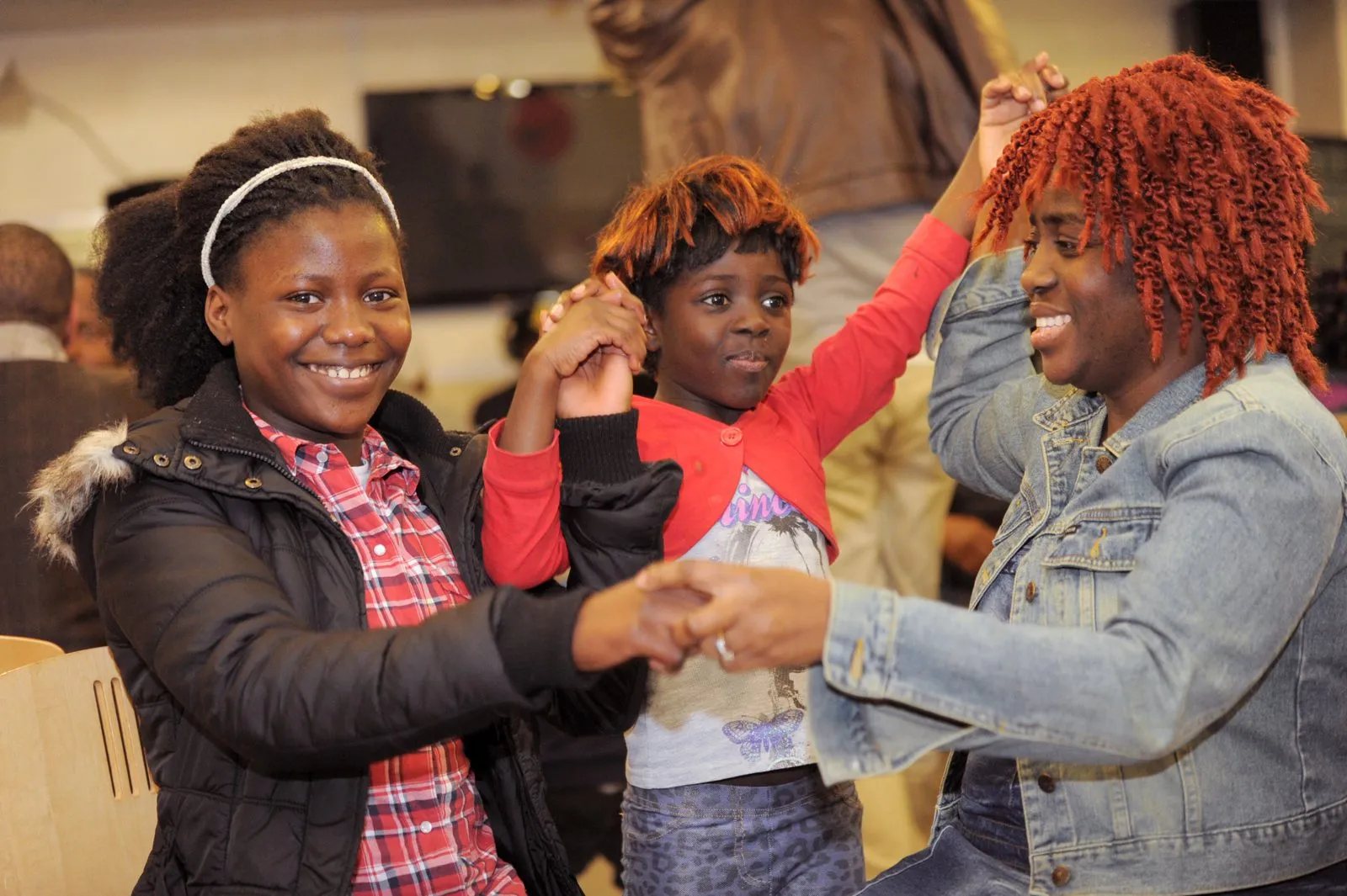 Women and children dancing together at a MEG community event