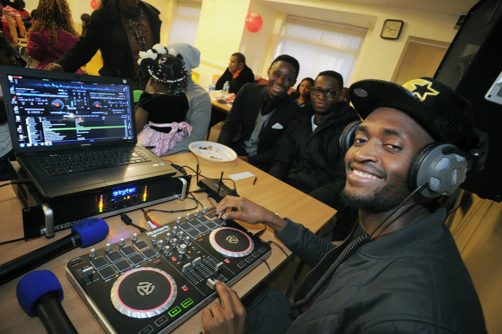 A volunteer DJ playing music at a MEG community event