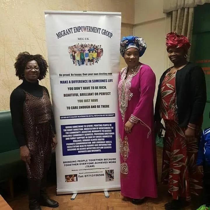 MEG team members in front of the Migrant Empowerment Group banner